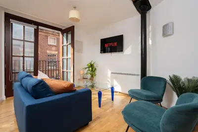 a living room with a blue couch and two chairs at VICHY - Temple Court Superb apartment in City Center in Liverpool