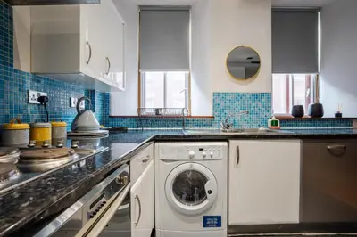 a kitchen with a washing machine and a sink at VICHY - Temple Court Superb apartment in City Center in Liverpool