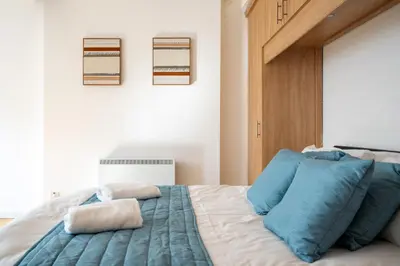 a bedroom with a bed with blue pillows on it at VICHY - Temple Court Superb apartment in City Center in Liverpool