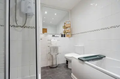 a white bathroom with a toilet and a shower at VICHY - Temple Court Superb apartment in City Center in Liverpool