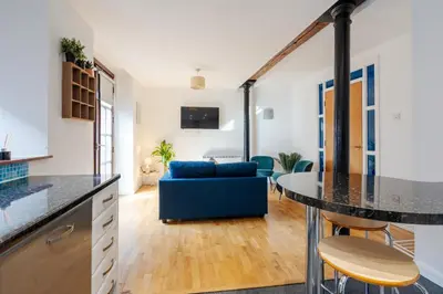 a kitchen and living room with a blue couch at VICHY - Temple Court Superb apartment in City Center in Liverpool