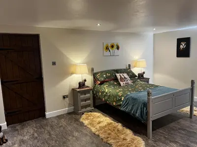 a bedroom with a bed and two lamps and a door at Luxury Country Lodge in Bretherton - Sleeps 4 in Bretherton