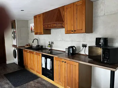 a kitchen with wooden cabinets and a microwave at Luxury Country Lodge in Bretherton - Sleeps 4 in Bretherton