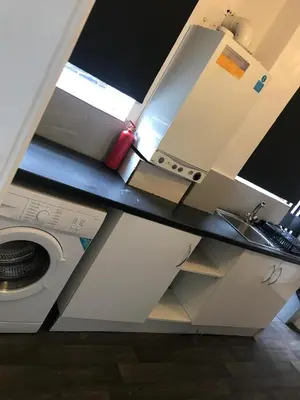 a kitchen with a sink and a washing machine at Noble Prestige Place in Liverpool