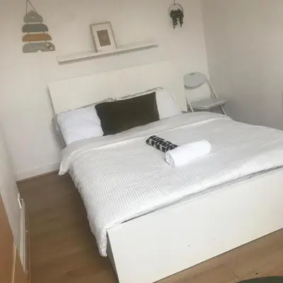 a white bed with a black and white comforter at Noble Prestige Place in Liverpool