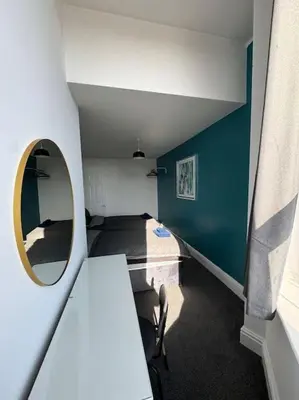 a room with a mirror and a table with a chair at Subway Apartments in Blackpool