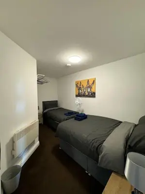 a bedroom with two beds and a tv in it at Subway Apartments in Blackpool