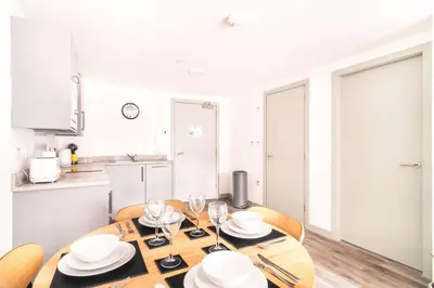 a dining room table with plates and wine glasses at Fabulous 1 Bed Apartment in Liverpool Centre in Liverpool