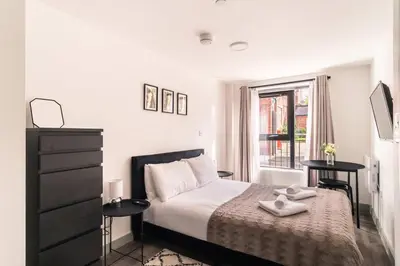 a white bedroom with a bed and a window at Fabulous 1 Bed Apartment in Liverpool Centre in Liverpool