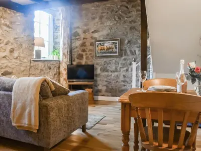 a living room with a couch and a table at The Old Loft in Slaidburn