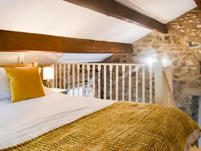 a bedroom with a bed with a yellow pillow at The Old Loft in Slaidburn