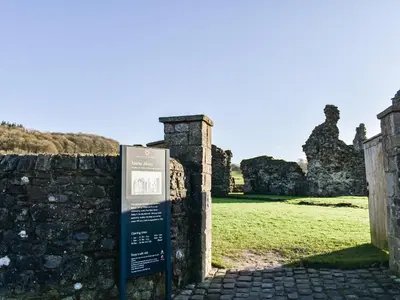 a sign in front of a stone wall with a field at The Old Loft in Slaidburn