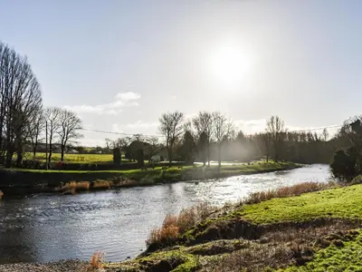 a river in the middle of a field at The Old Loft in Slaidburn