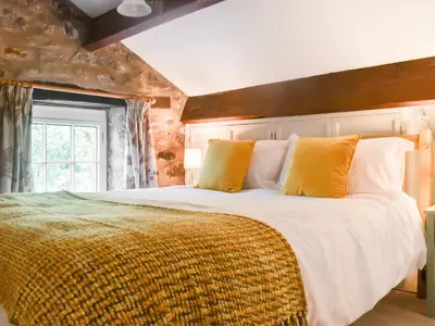 a bedroom with a large bed with yellow pillows at The Old Loft in Slaidburn