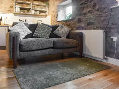 a living room with a couch and a radiator at The Old Loft in Slaidburn