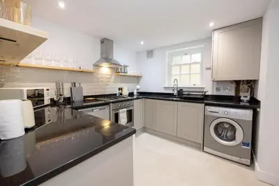 a kitchen with a sink and a washing machine at GuestReady - Georgian Quarter retreat with terrace in Liverpool