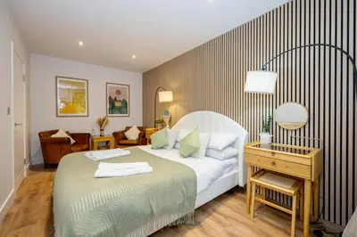 a bedroom with a bed and a desk with a bed sidx sidx sidx at GuestReady - Georgian Quarter retreat with terrace in Liverpool