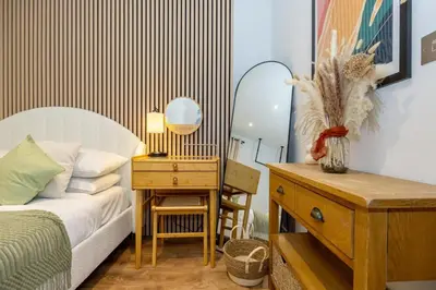a bedroom with a bed and a desk with a mirror at GuestReady - Georgian Quarter retreat with terrace in Liverpool