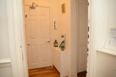 a hallway with a white door with a plant on it at Cosy Orrell Park Retreat Near Anfield and Aintree in Liverpool