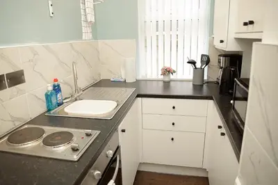 a kitchen with a sink and a counter top at Cosy Orrell Park Retreat Near Anfield and Aintree in Liverpool