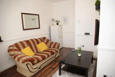 a living room with a couch and a table at Cosy Orrell Park Retreat Near Anfield and Aintree in Liverpool