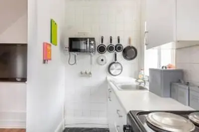 a white kitchen with a stove and a sink at Cheerful Maisonette in the heart of Orrell Park in Liverpool