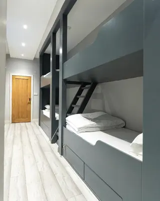 a bedroom with bunk beds with a wooden floor at Charles Alexander Short Stay - Vibe Apartments in Blackpool