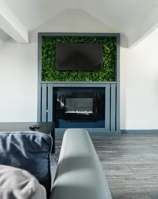 a living room with a fireplace with a television on a wall at Charles Alexander Short Stay - Vibe Apartments in Blackpool