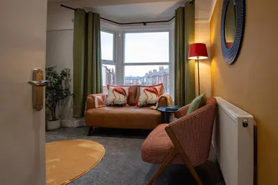 a living room with a chair and a window at Britannia Apartments in Liscard Village Wallasey by Rework Accommodation in Wallasey