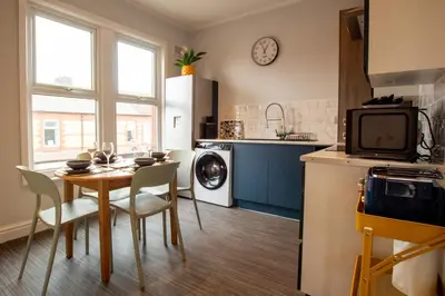 a kitchen and dining room with a table and a microwave at Britannia Apartments in Liscard Village Wallasey by Rework Accommodation in Wallasey