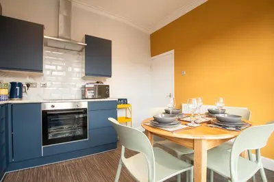 a kitchen with a table and chairs in a kitchen at Britannia Apartments in Liscard Village Wallasey by Rework Accommodation in Wallasey