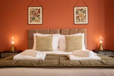 a bedroom with a large bed with orange walls at Britannia Apartments in Liscard Village Wallasey by Rework Accommodation in Wallasey