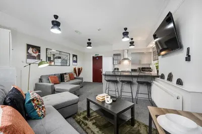 a living room with a couch and a table at Anfield Cosy Stays - Air Host & Stay - Sleeps 14 in Liverpool