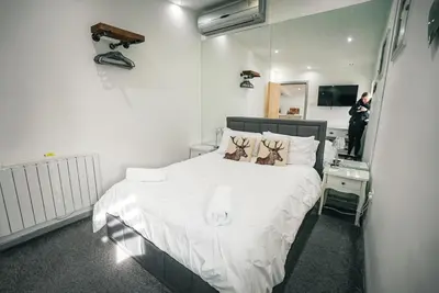 a bedroom with a white bed and a person taking a picture at The Old Lambing Barn in Longton