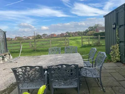 a table and chairs with a view of a field at The Old Lambing Barn in Longton