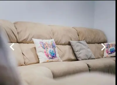 a brown couch with four pillows on it at The Cow Shed in Longton