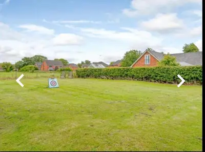 a yard with two signs in the grass at The Cow Shed in Longton