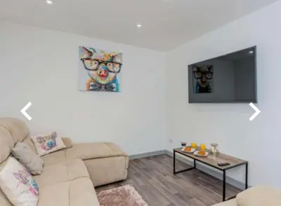 a living room with a couch and a flat screen tv at The Cow Shed in Longton