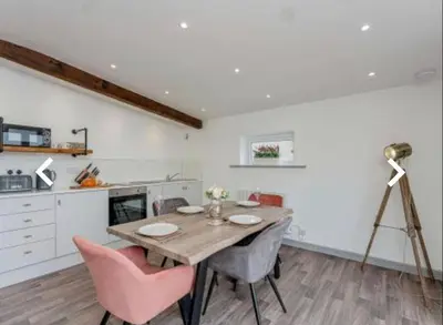 a kitchen and dining room with a table and chairs at The Cow Shed in Longton