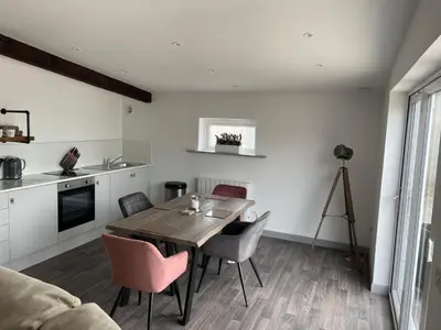 a kitchen and dining room with a table and chairs at The Cow Shed in Longton
