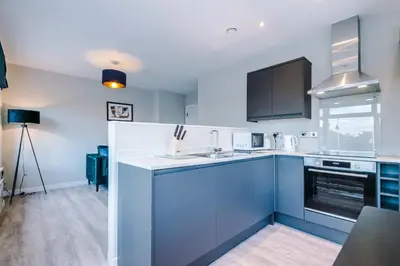 a kitchen with a sink and a stove top oven at Elysée Suites - Spacious 1 Bed Flat in Southport in Southport