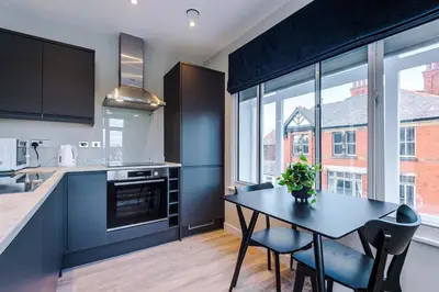 a kitchen with a table and chairs and a kitchen with a window at Elysée Suites - Spacious 1 Bed Flat in Southport in Southport