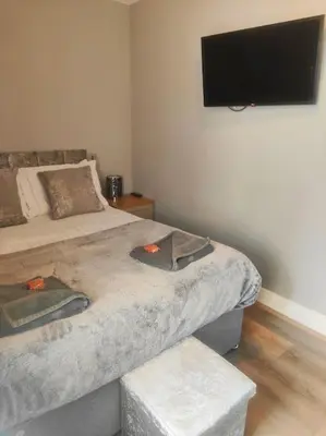 a bedroom with two beds and a flat screen tv at Chelsea 2 bedroom promenade apartment in Blackpool
