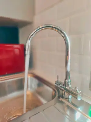 a kitchen sink with water coming out of a faucet at Chelsea 2 bedroom promenade apartment in Blackpool