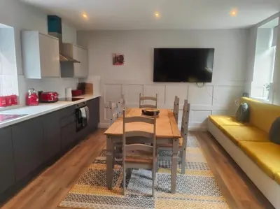 a kitchen and dining room with a table and a couch at Chelsea 2 bedroom promenade apartment in Blackpool