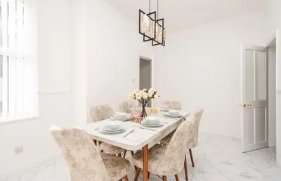 a white dining room with a white table and chairs at Liverpool Luxe Retreat 3 Bedroom House Next to Everton Stadium in Liverpool