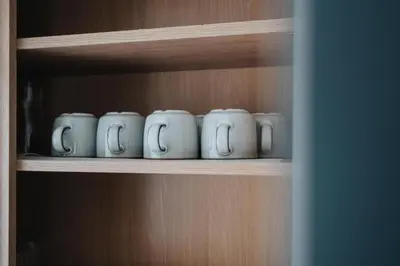 a row of coffee cups sitting on a shelf at Liverpool Luxe Retreat 3 Bedroom House Next to Everton Stadium in Liverpool
