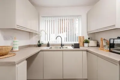 a white kitchen with a sink and a window at Liverpool Luxe Retreat 3 Bedroom House Next to Everton Stadium in Liverpool