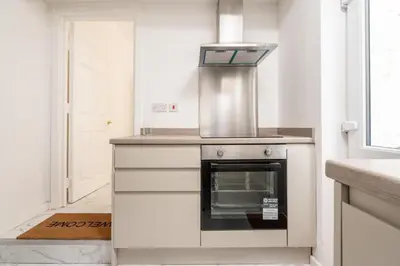 a kitchen with a stove top oven next to a door at Liverpool Luxe Retreat 3 Bedroom House Next to Everton Stadium in Liverpool
