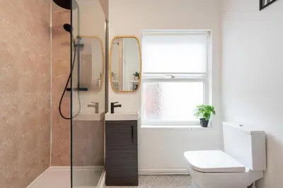 a bathroom with a shower with a toilet and a sink at Liverpool Luxe Retreat 3 Bedroom House Next to Everton Stadium in Liverpool